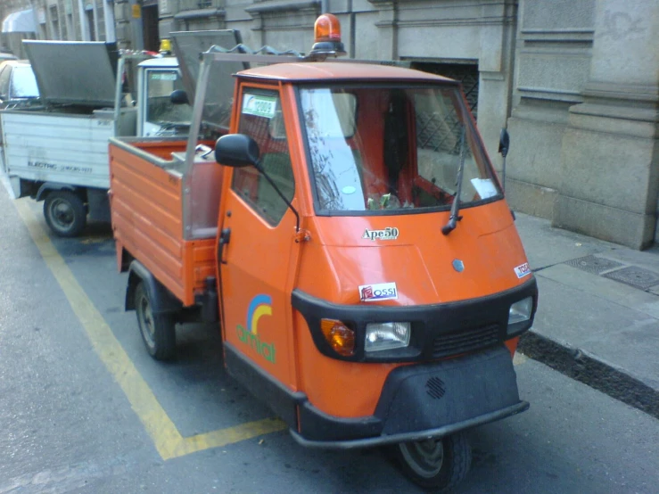 two small utility vehicles driving in a city street