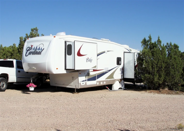 a couple of white trucks and a small travel trailer