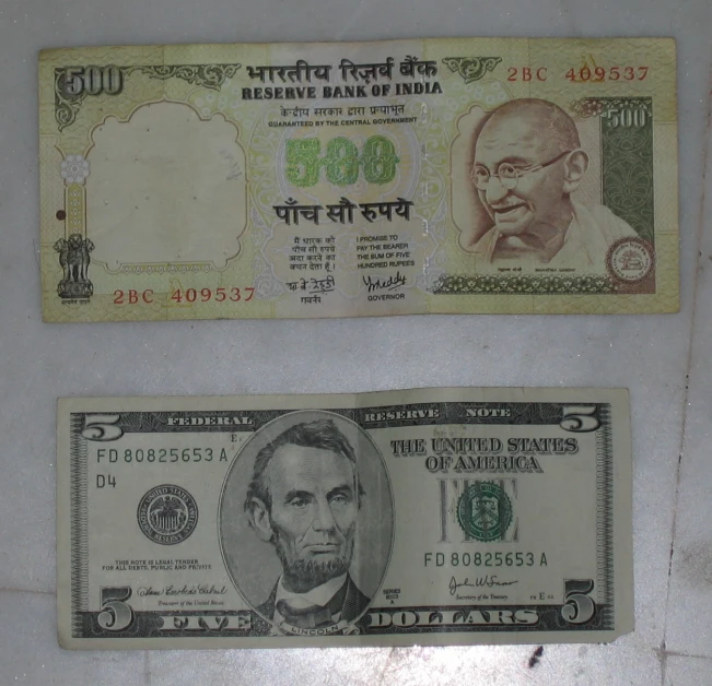 two indian currency is being displayed on a table