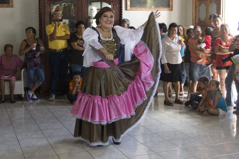 a woman is dressed in spanish attire dancing with other people