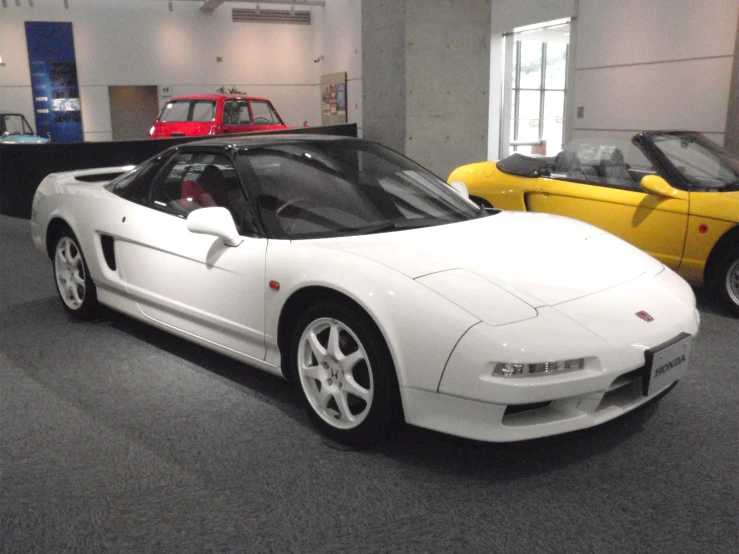 white car with red seats in display at indoor dealership