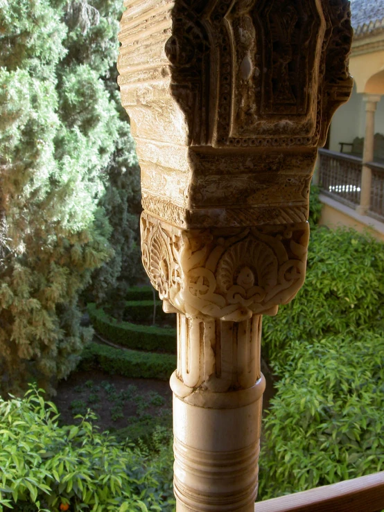 a pillar on the side of a building with plants behind it