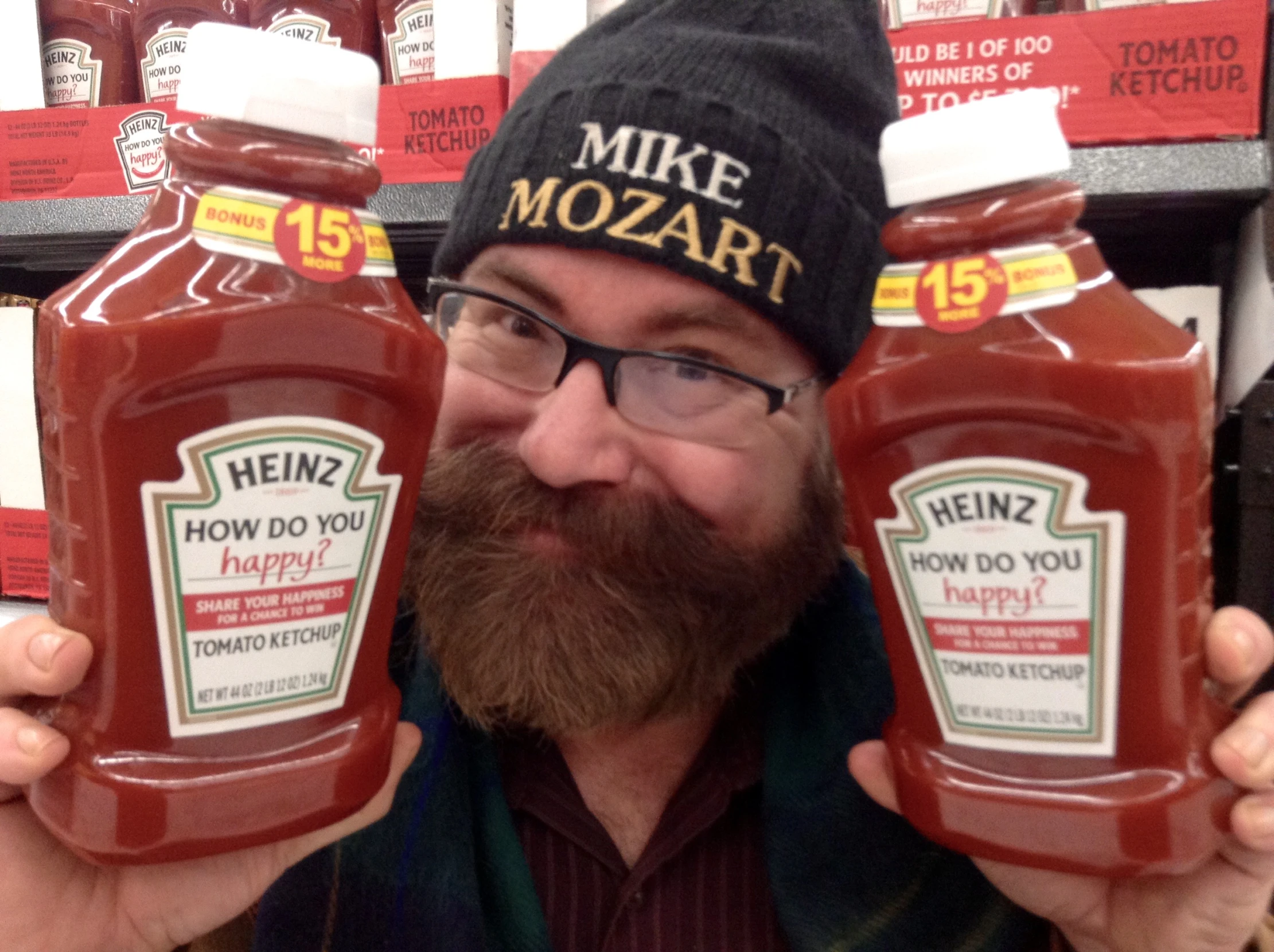 man holding up two jars of ketchup next to each other