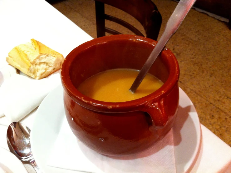 the soup sits in an orange clay pot
