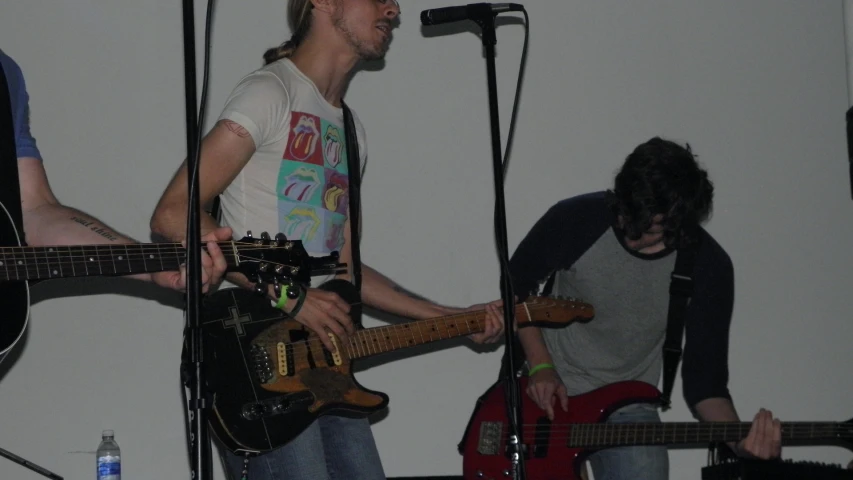 a young man is holding a guitar and singing