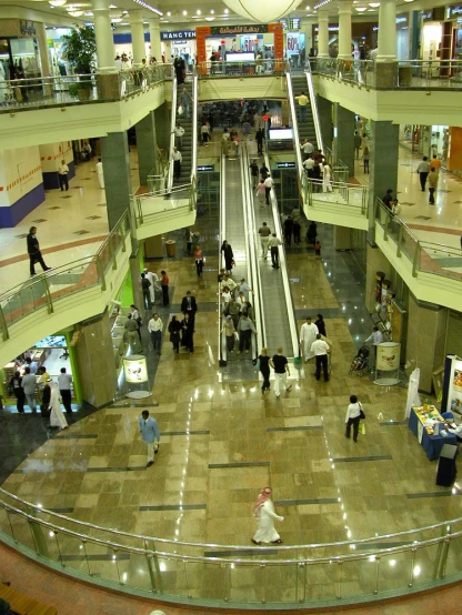 an overhead s of the shopping center with many people on the walkway and escalators