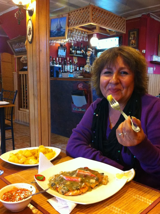 a woman sitting at a table eating food