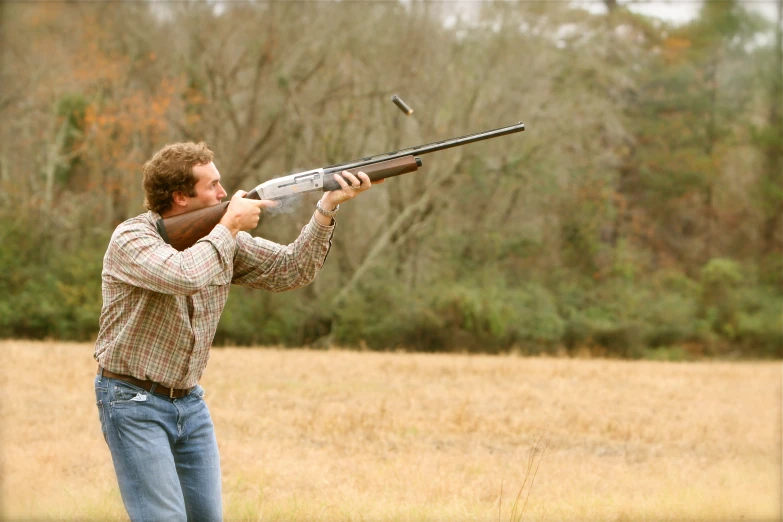 a man with a gun is aiming at a bird