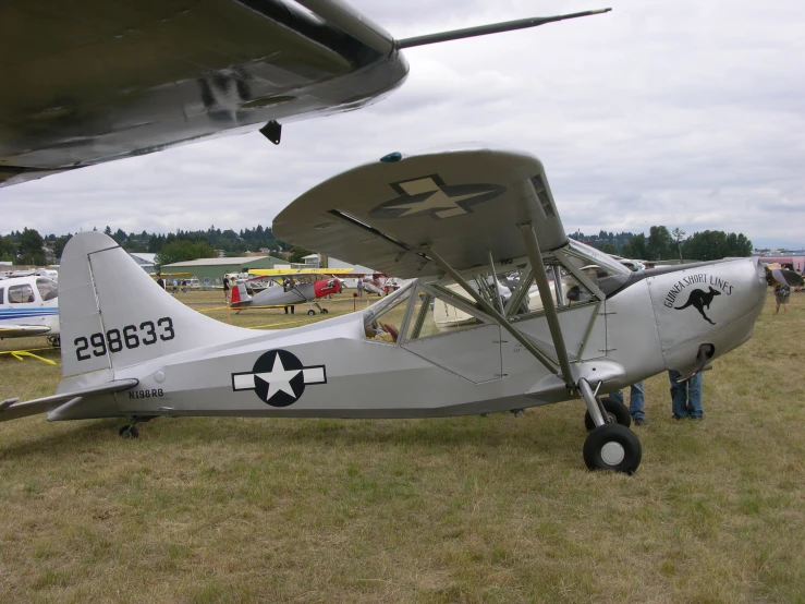 an old style airplane parked in a field