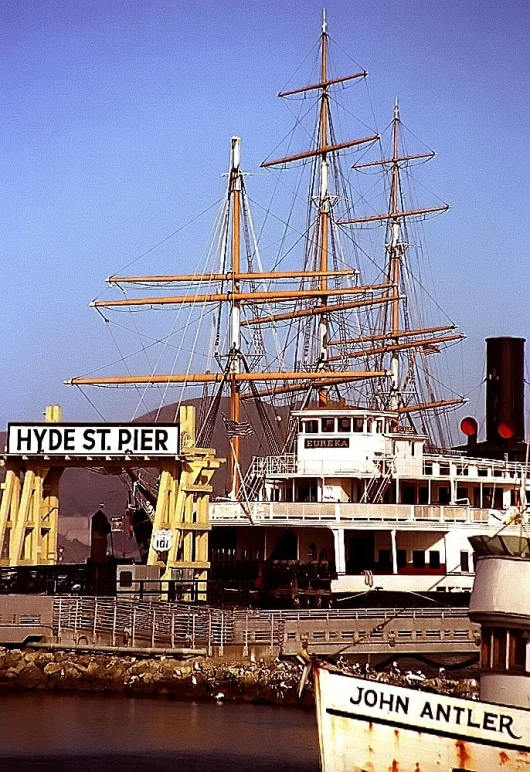 a ship is sitting in the water near a pier