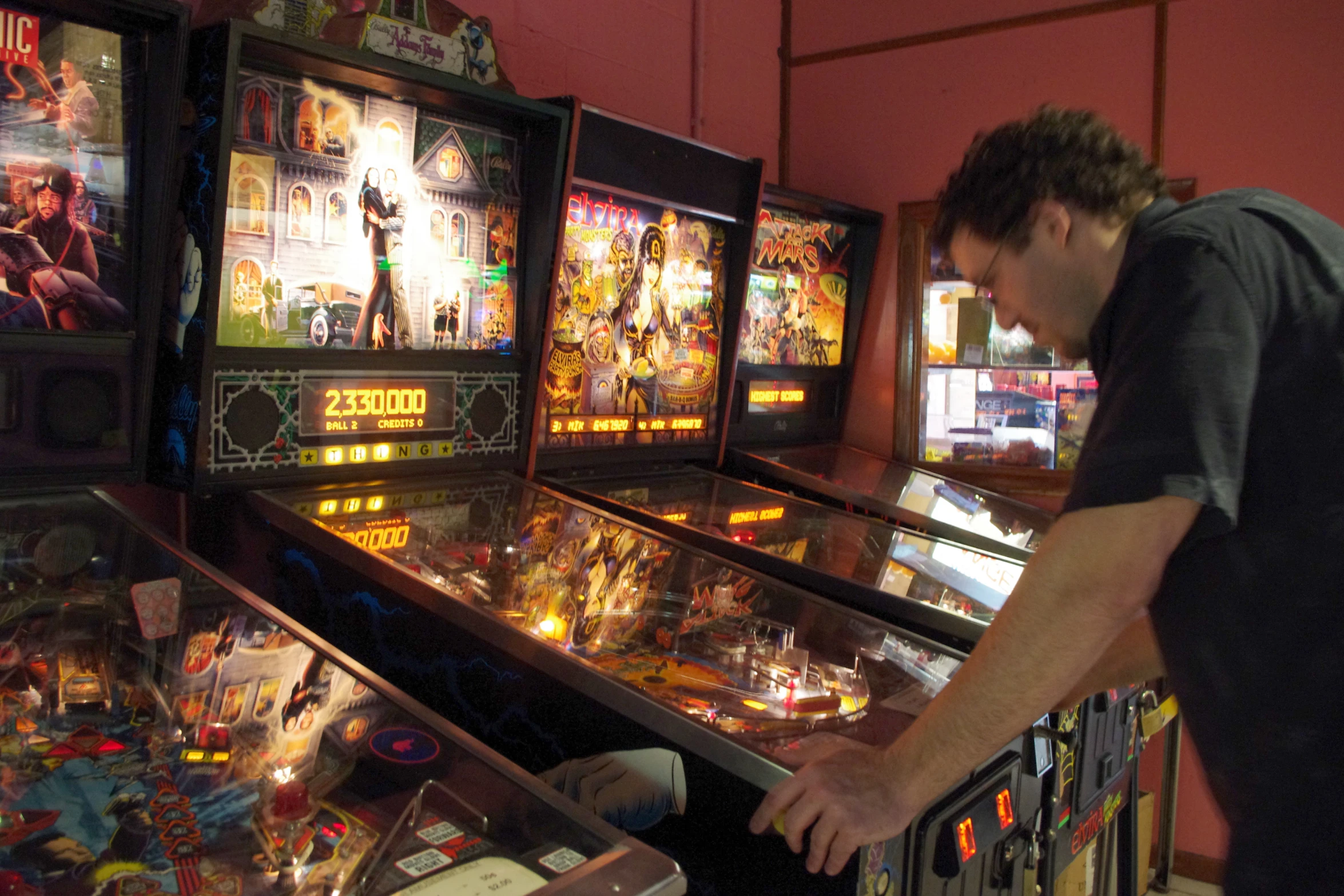 a man looking at pinball machines in a store