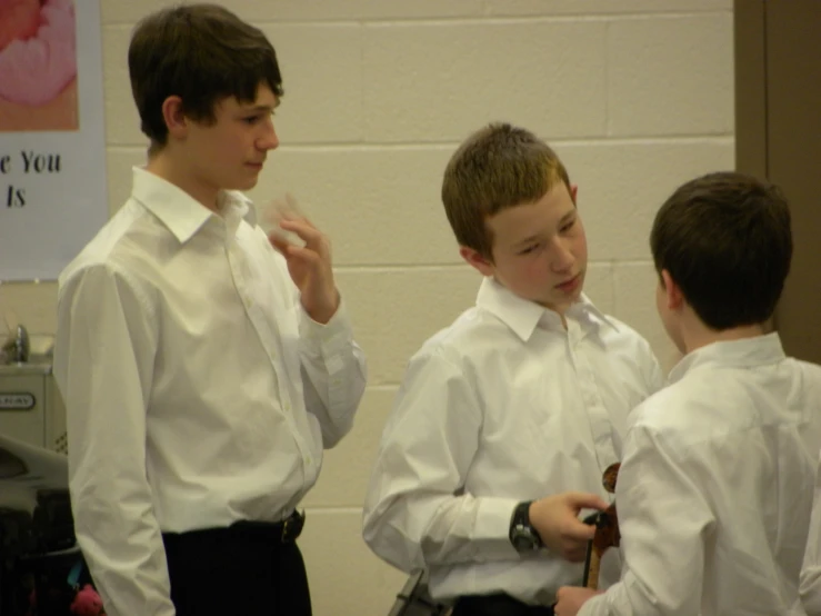 three s dressed in shirts and ties are standing together