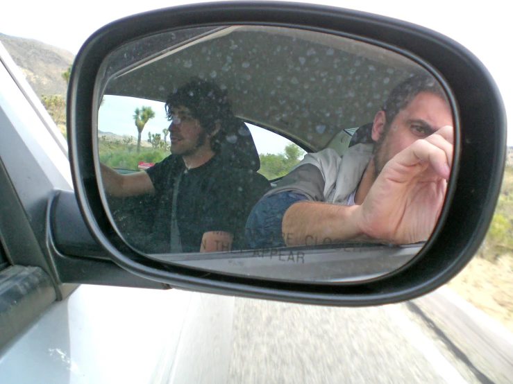 an image of two men driving a car in the rain