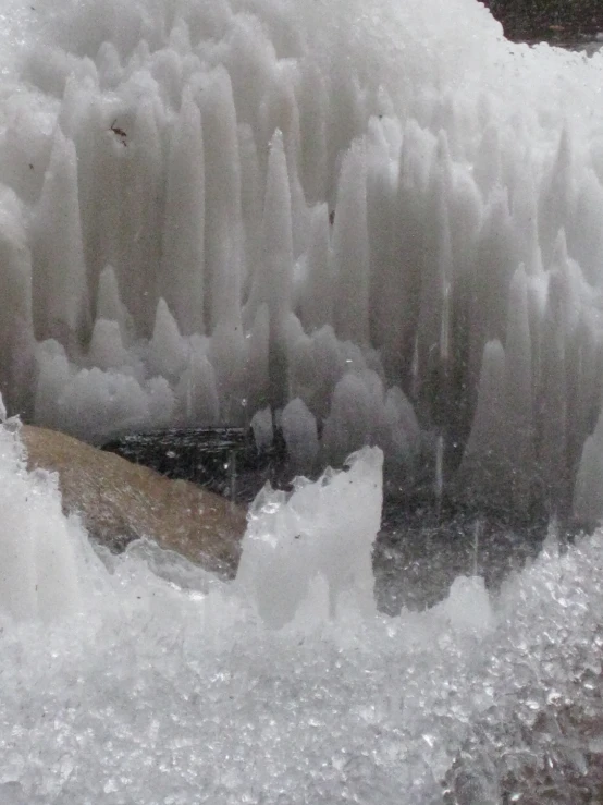 an icy waterfall with rocks and water pouring from the water