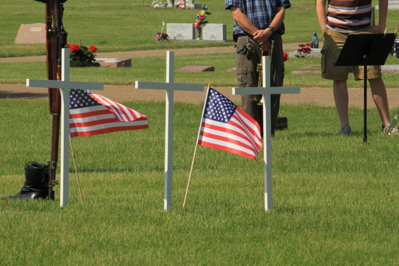 two flags are lying near crosses on a field