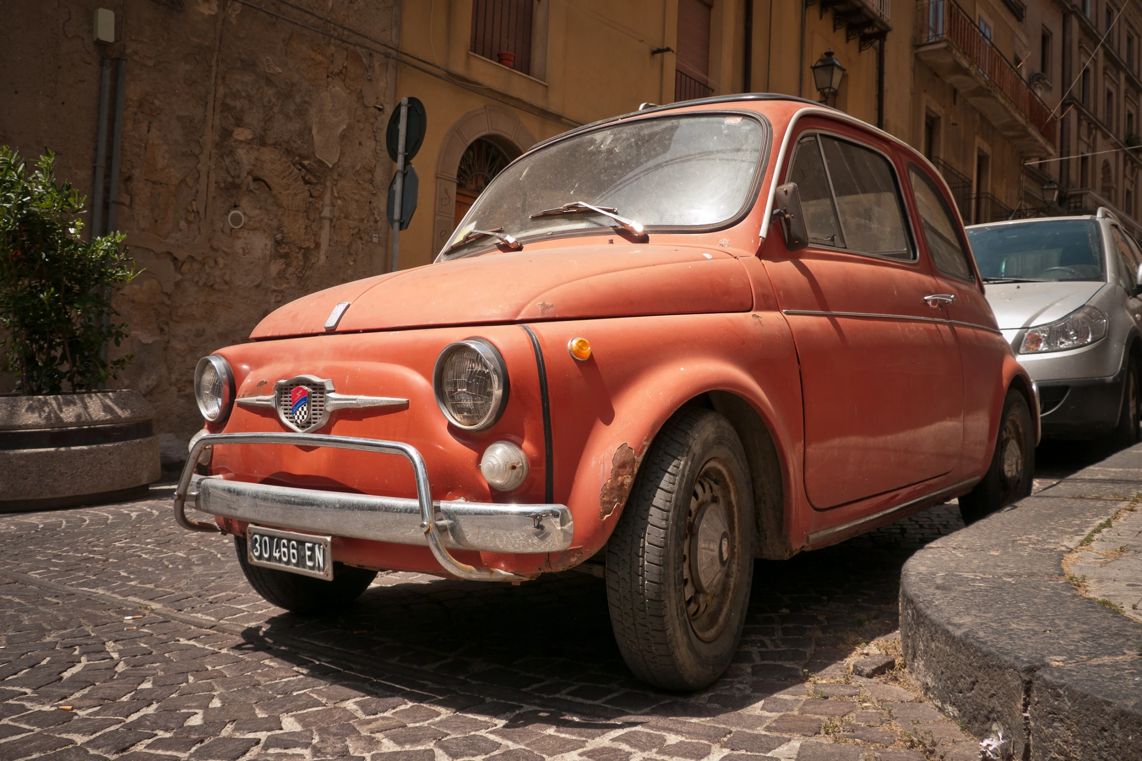 a very cute looking old car parked near a building