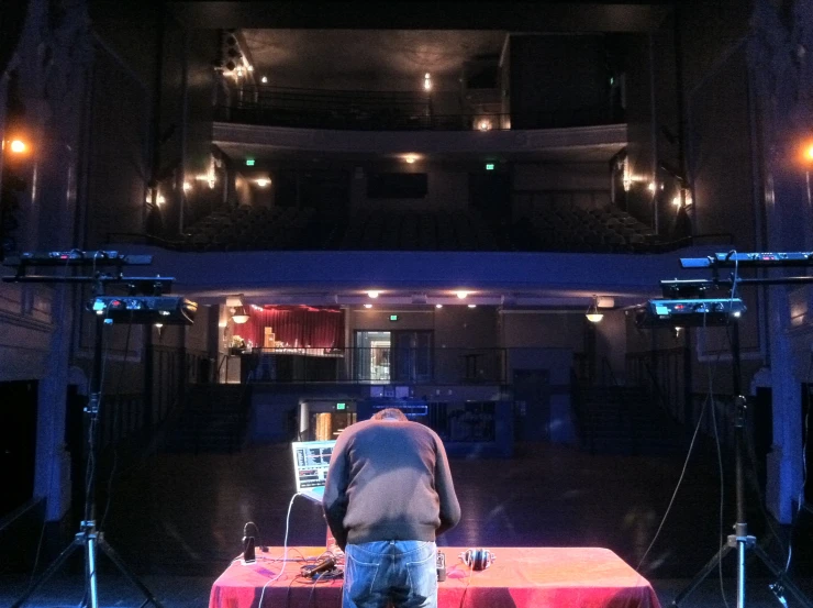 a large stage with lights on and a man at the end