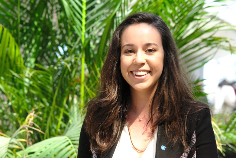 a woman standing next to some palm trees