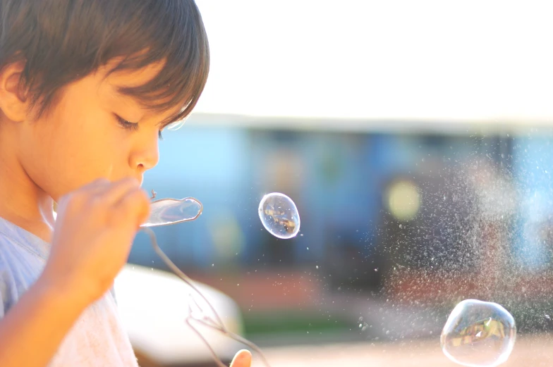 a boy blowing a bunch of bubbles on his fingers