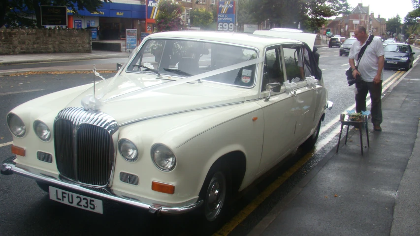 the vintage car is decorated with an elaborate white ribbon