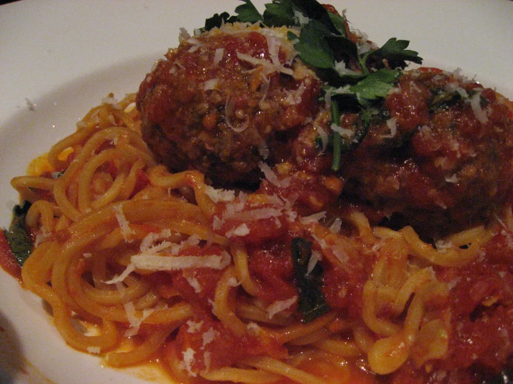 two meatballs on top of pasta in tomato sauce