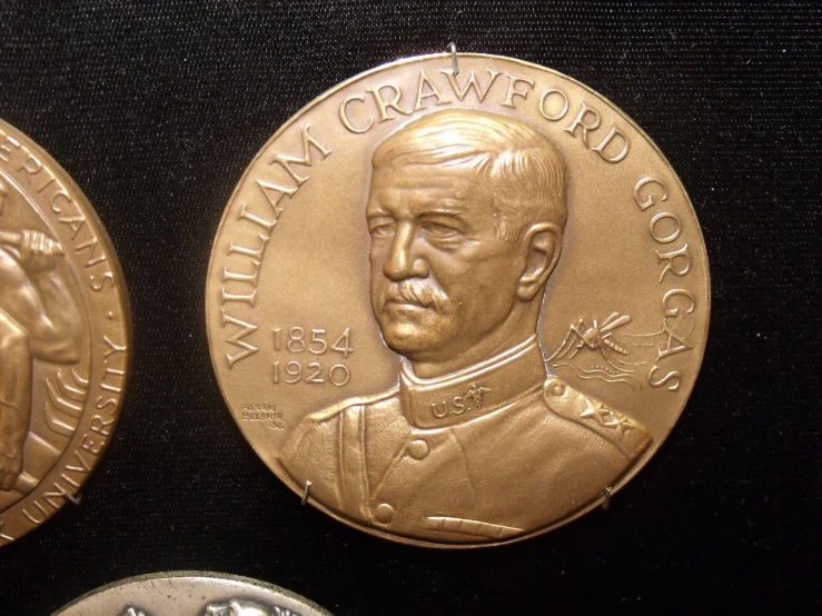 two gold commemorative coins, one with an officer on the front and one without an officer on