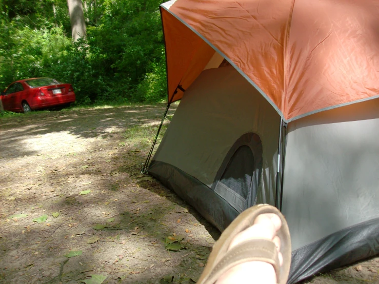 an orange tent is pitched up on a path