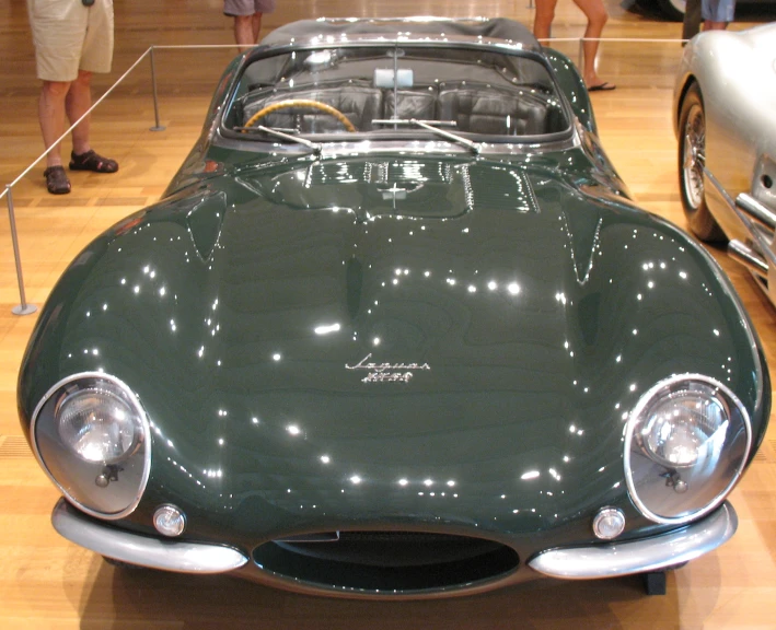 an old car is displayed on a wooden floor