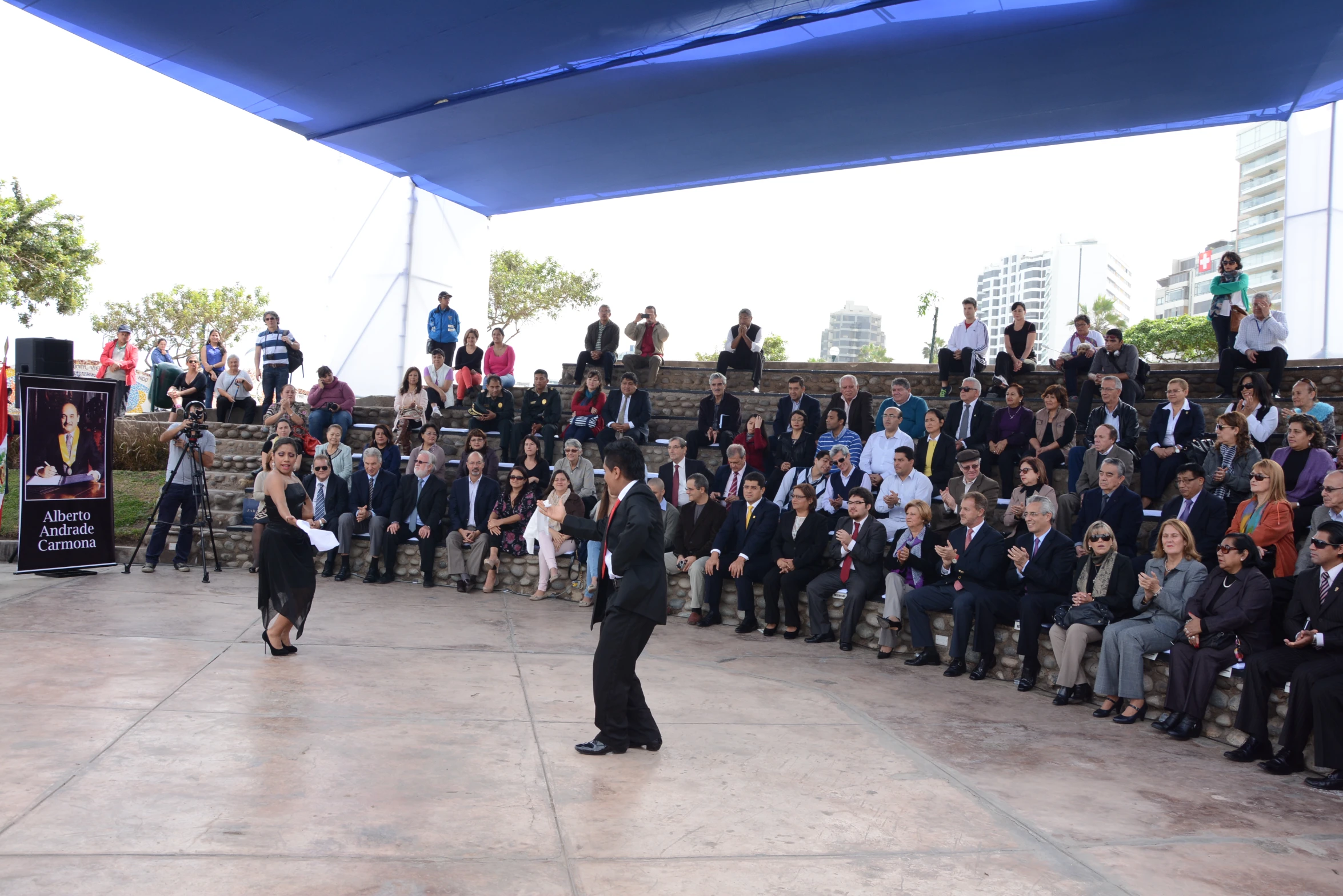 an audience watches as people in formal attire are shown