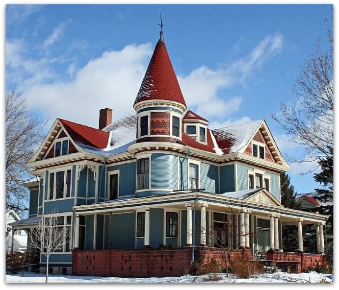 a victorian style house in winter covered with snow