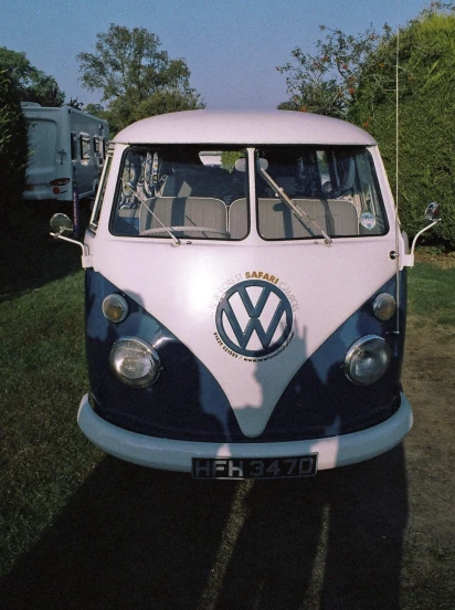 an old volkswagen bus is parked on the side of the road
