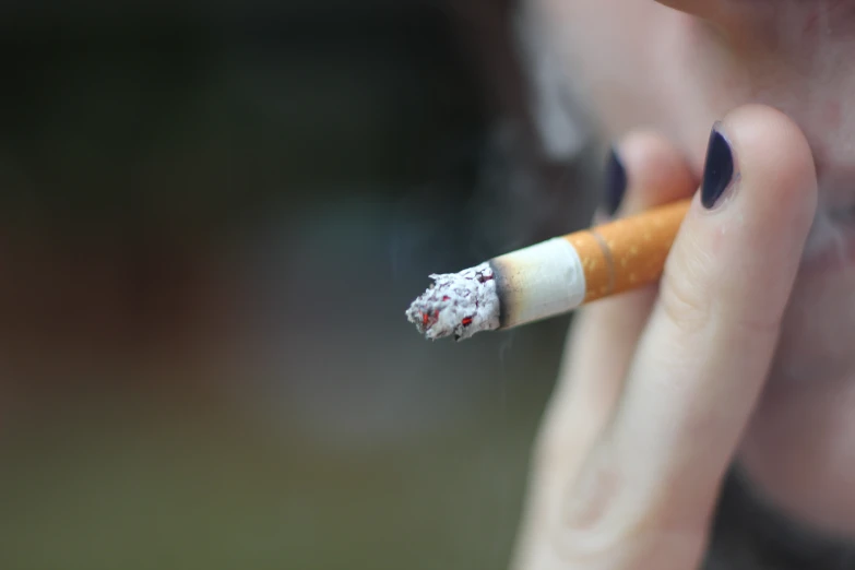 a person smoking a cigarette in their hands