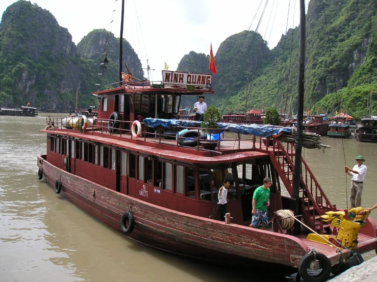 a red tour boat with tourists at a dock