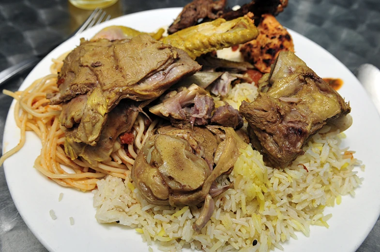 a plate of food containing meat and rice