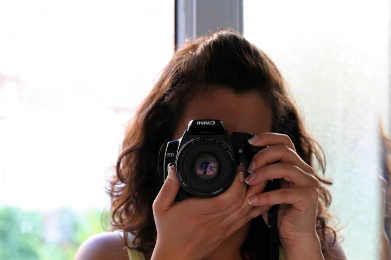 woman taking po with a canon camera inside a home