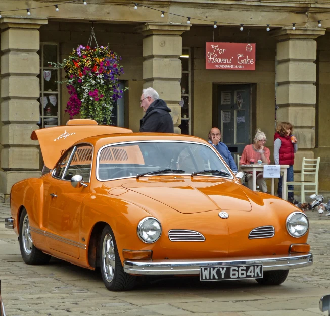 an orange car with a trunk over it's hood