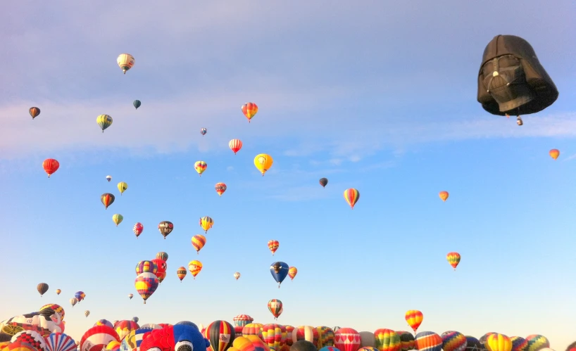 several air balloons are being flown in the sky