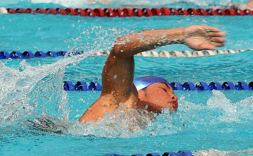 a young man swims in a pool