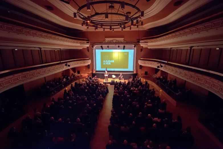 a big screen in a building with a crowd of people around it