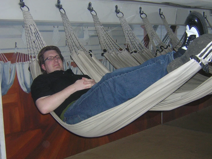 a man sitting in a hammock with feet up