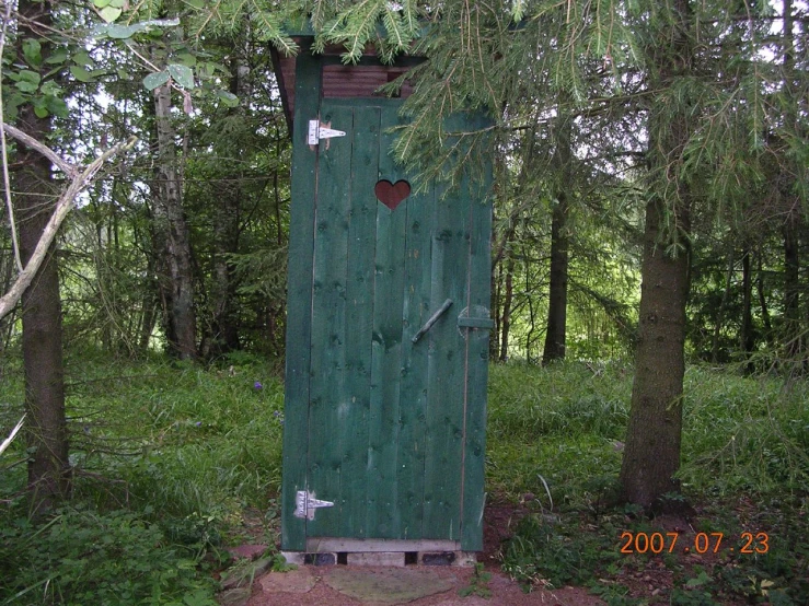 a large outhouse that is in the woods