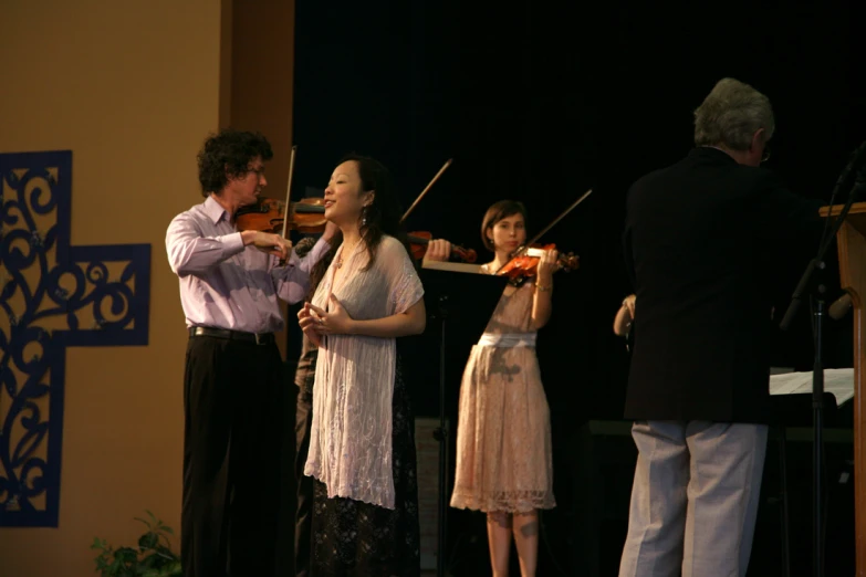 a man plays violin while his family watches