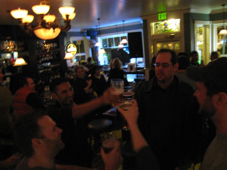 a group of men standing next to each other at a bar