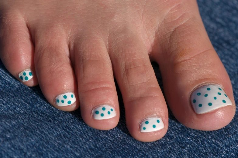 woman's toe with nail polish and blue dotted dots