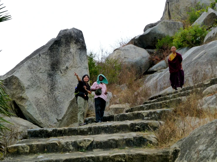 a group of women walking down the steps in front of some rocks