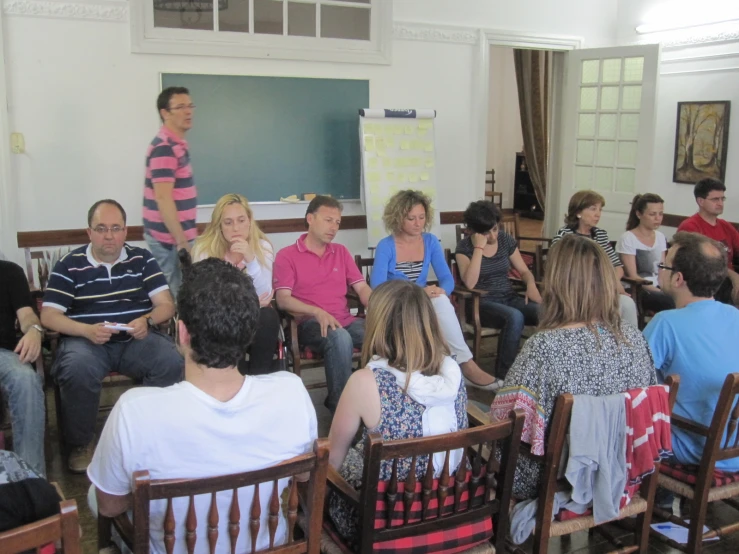 a room filled with people and one man standing up