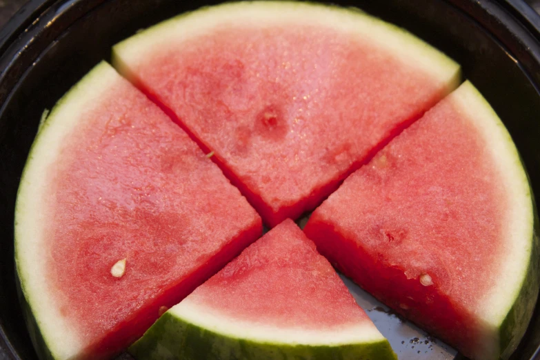 several pieces of watermelon being cut in small sections