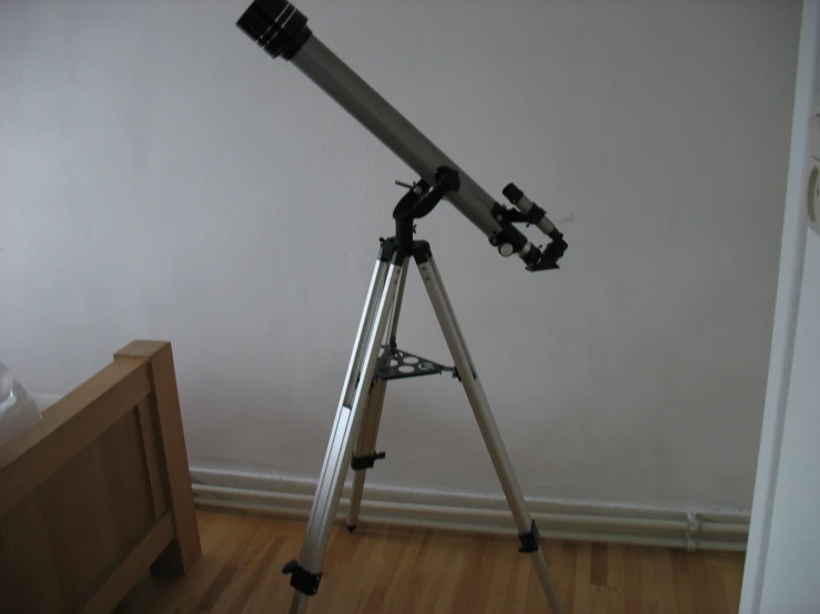 a large telescope on a tripod in a room
