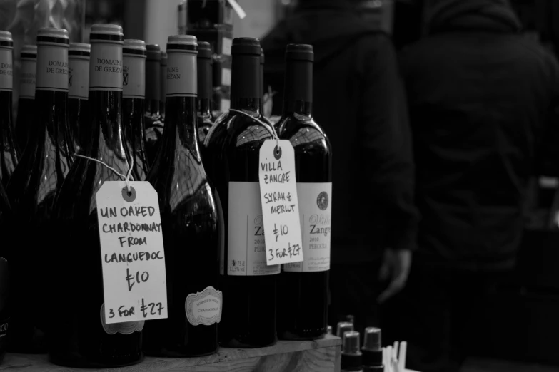 black and white pograph of bottles of wine at a wine stand