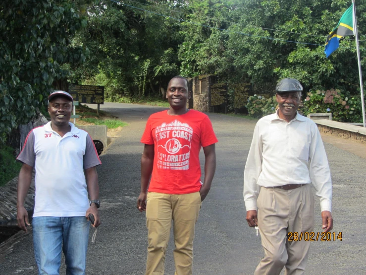 three men standing by each other on a road